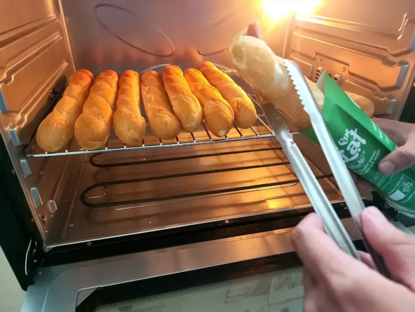 Làm nóng bánh mì que tại điểm bán Dalabami