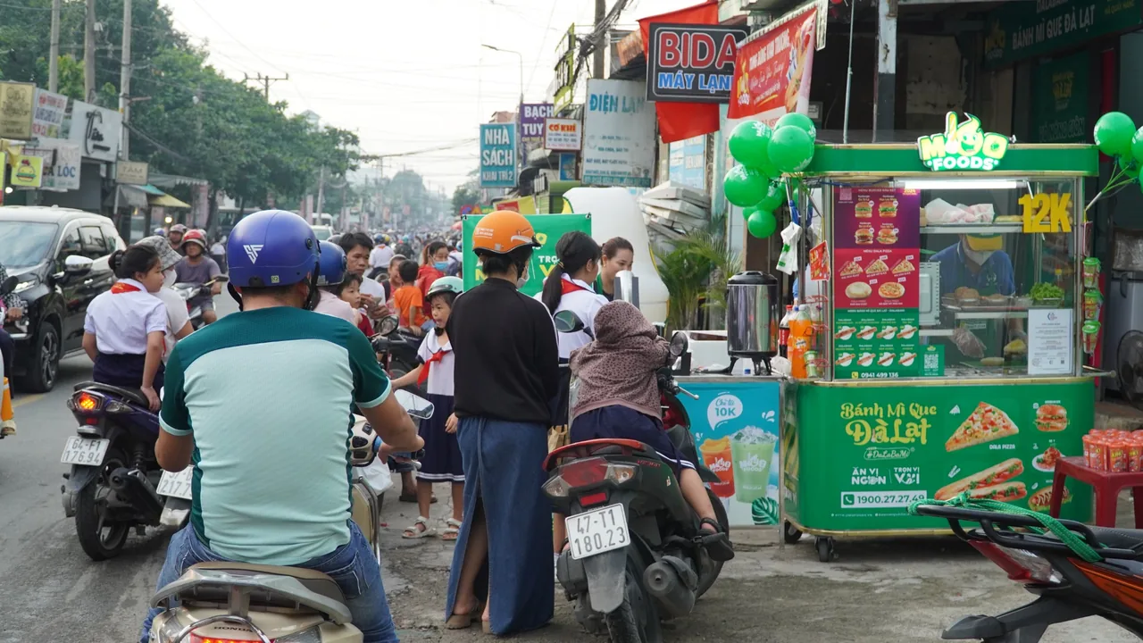 Quầy bánh mì gần trường học với học sinh và người đi đường qua lại