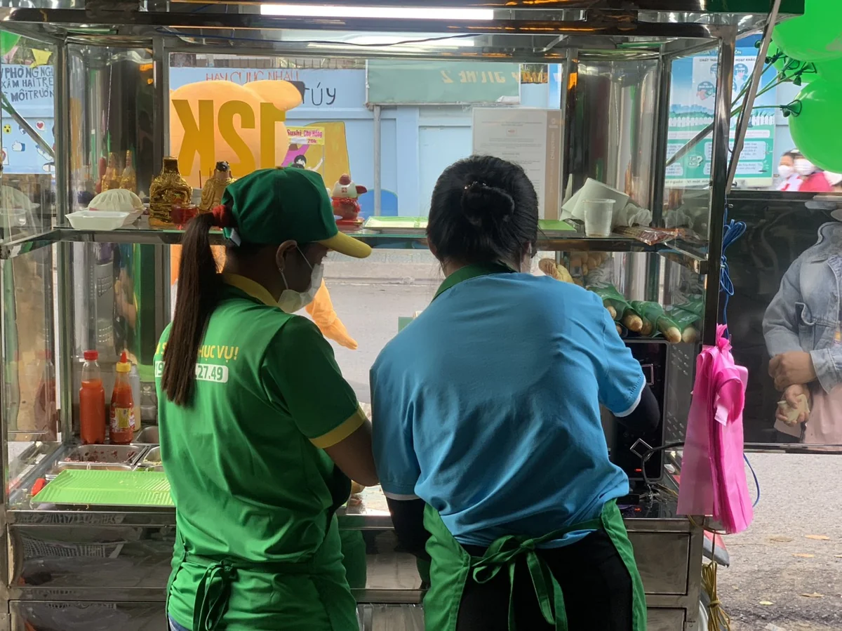 Hai người thao tác tại quầy bánh mì