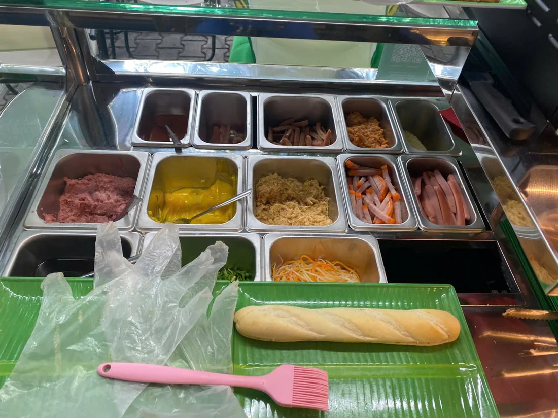 Các khay nhân bánh mì và ổ bánh mì đặt trên bàn thao tác